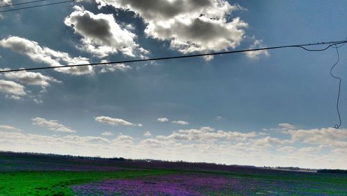 Scenic view of field against cloudy sky