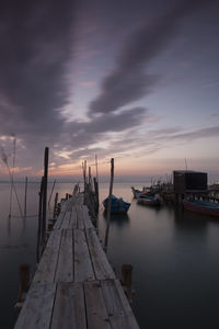 Pier over sea against sky at sunset