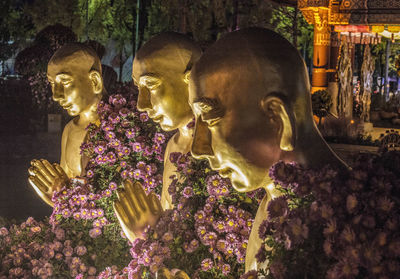 Sculpture of buddha statue outside temple against building