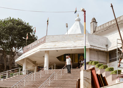 Rear view of woman on staircase against building