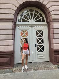 Full length of woman standing in front of old building