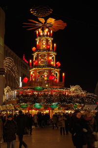 People on illuminated christmas tree at night