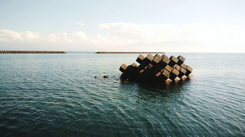 Groyne in sea against sky