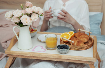Romantic breakfast with coffee, waffles, orange juice and rose flowers.