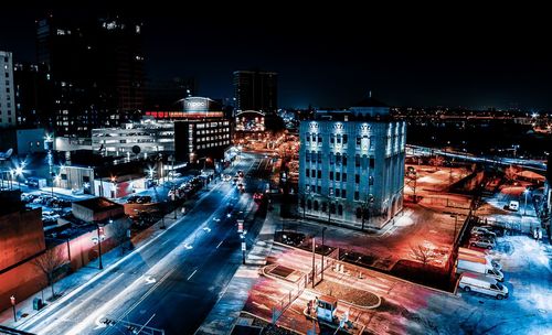 High angle view of illuminated city street and buildings at night