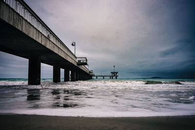 Bridge over sea against sky in a cloudy cold morning.