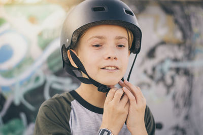 Close-up of boy wearing crash helmet outdoors