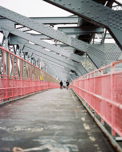 Rear view of people walking on bridge