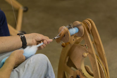Cropped image of man working with loom in workshop