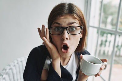 Portrait of young woman with coffee cup