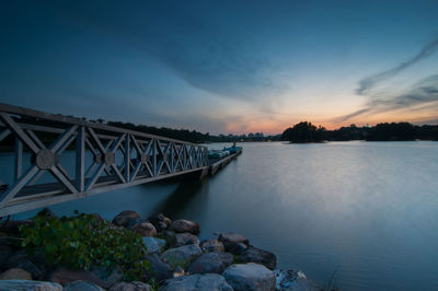 Floating jetty over lake against sky during sunset