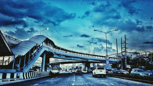 Suspension bridge against cloudy sky