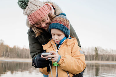 Mom looking at a camera with her son outside taking pictures