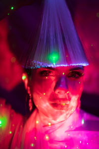 Close-up of portrait of woman with illuminated lighting