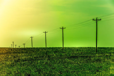 Electricity pylon on field against sky