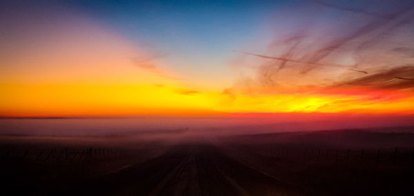 Scenic view of landscape against romantic sky at sunset