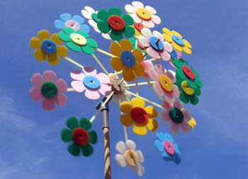 Low angle view of pinwheel toy against blue sky