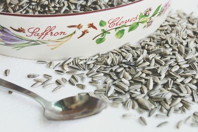 Close-up of sunflower seeds in bowl with spoon