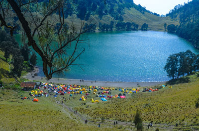 High angle view of people on camping base next to mountain lake