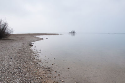 Scenic view of lake against sky during winter