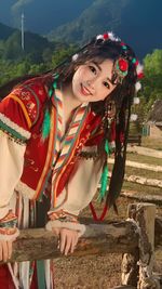 Low angle view of young woman standing against railing