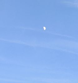 Low angle view of moon against blue sky