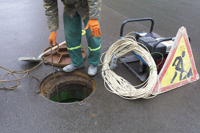 Low section of man by equipment working on street