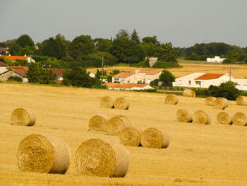 Hay bales on field against sky
