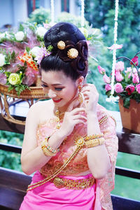 Young woman with pink flower petals on plant