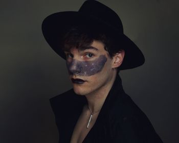 Portrait of young man against black background