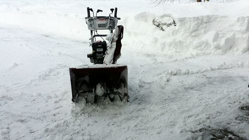 Tractor on snowy field against sky