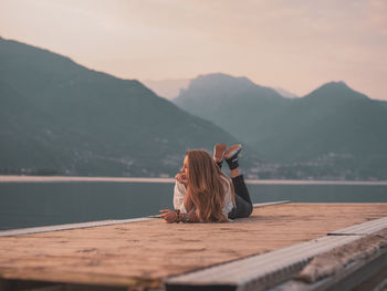 Woman relaxing in lake against mountain range