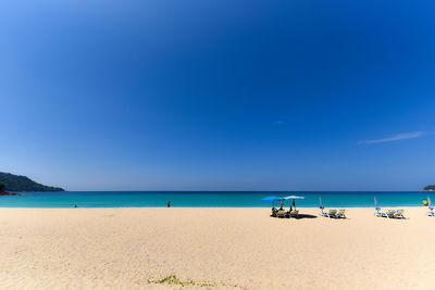 Scenic view of beach against clear blue sky