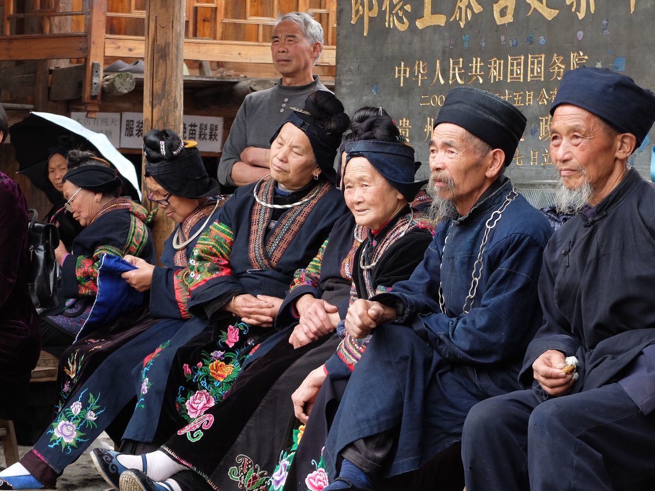 GROUP OF PEOPLE IN TRADITIONAL CLOTHING HOLDING CAMERA