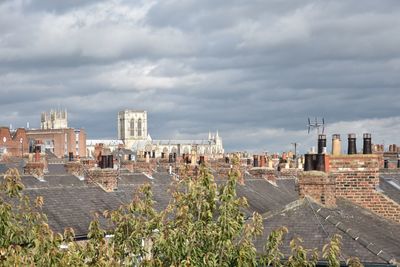 High angle view of buildings in city against cloudy sky