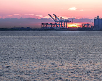 Pier over sea against sky during sunset