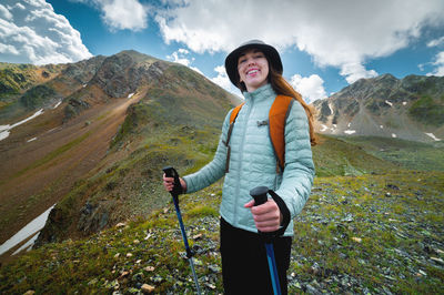 Portrait, the girl is happy and smiling while hiking in the mountains. beautiful young caucasian