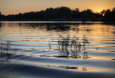Scenic view of lake against sky at sunset