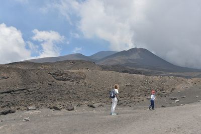 Rear view of woman standing on mountain landscape