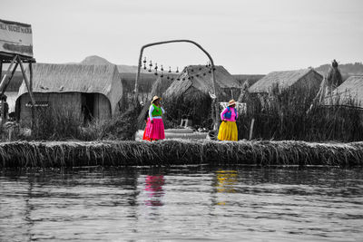 People on lake against clear sky