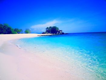 Scenic view of beach against blue sky