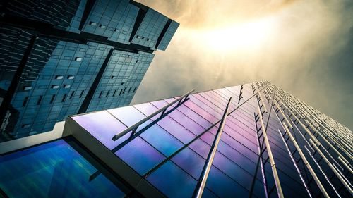 Low angle view of modern glass building against sky