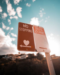 Low angle view of road sign against sky