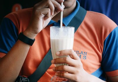 Midsection of man holding drink