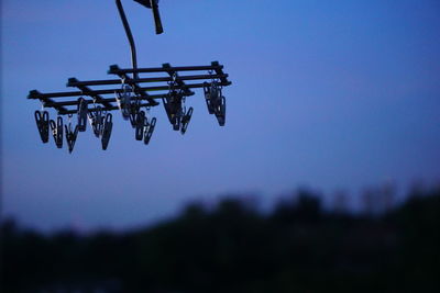 Low angle view of clothespins on clothesline against sky