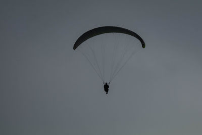 Low angle view of person paragliding against sky