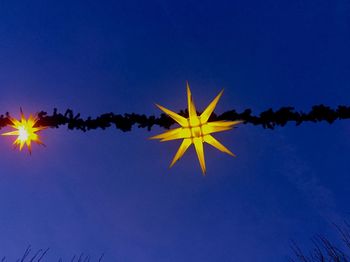 Low angle view of airplane flying against clear blue sky
