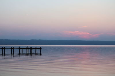 Pier on sea against sky during sunset