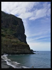 Scenic view of sea and mountains against sky