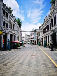 Street amidst buildings in town against sky